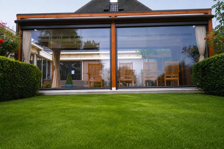 Wide glass veranda garden room with timber posts onto a lawn